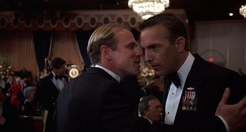 Movie still from “No Way Out” (1987), directed by Roger Donaldson – A couple of men standing next to each other; Close Up shot, Low angle