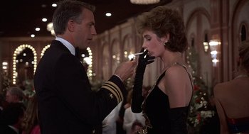 Movie still from “No Way Out” (1987), directed by Roger Donaldson – A man and a woman in formal wear smoking; Medium shot, Low angle