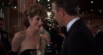Movie still from “No Way Out” (1987), directed by Roger Donaldson – A man and a woman talking to each other at an event; Close Up shot, Over the shoulder angle