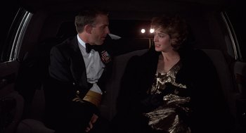 Movie still from “No Way Out” (1987), directed by Roger Donaldson – A man and a woman sitting next to each other; Medium shot, Over the shoulder angle