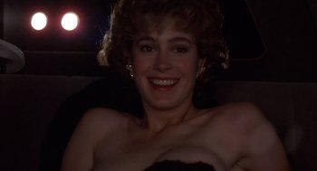 Movie still from “No Way Out” (1987), directed by Roger Donaldson – A woman sitting in the back seat of a car at night; Close Up shot, Low angle