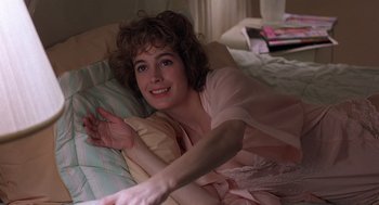 Movie still from “No Way Out” (1987), directed by Roger Donaldson – A woman laying on a bed in a room; Close Up shot, High angle