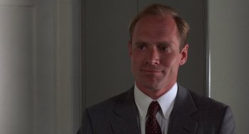 Movie still from “No Way Out” (1987), directed by Roger Donaldson – A person wearing a suit and tie; Close Up shot, Low angle