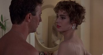 Movie still from “No Way Out” (1987), directed by Roger Donaldson – A man and a woman looking at each other in front of a mirror; Close Up shot, Over the shoulder angle