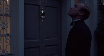 Movie still from “No Way Out” (1987), directed by Roger Donaldson – A man standing in front of a door at night; Medium shot, Low angle