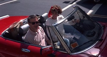 Movie still from “No Way Out” (1987), directed by Roger Donaldson – A man and a child in a red car; Medium shot, High angle
