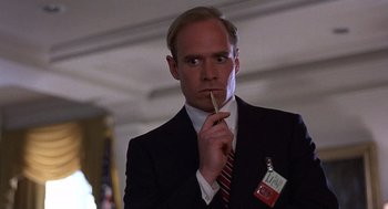 Movie still from “No Way Out” (1987), directed by Roger Donaldson – A man in a suit and tie holding a pencil; Close Up shot, Low angle