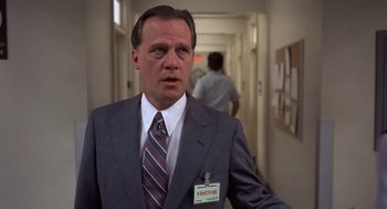 Movie still from “No Way Out” (1987), directed by Roger Donaldson – A man in a suit and tie standing in a hallway; Close Up shot, Low angle