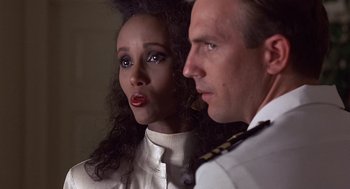 Movie still from “No Way Out” (1987), directed by Roger Donaldson – A man and a woman standing next to each other; Close Up shot, Over the shoulder angle