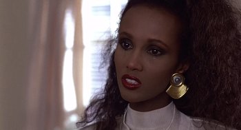 Movie still from “No Way Out” (1987), directed by Roger Donaldson – A person wearing a white shirt and gold earrings; Close Up shot, Over the shoulder angle