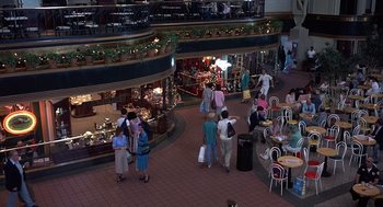 Movie still from “No Way Out” (1987), directed by Roger Donaldson – A group of people walking around a shopping center; Extreme Wide shot, High angle