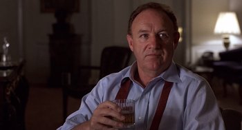 Movie still from “No Way Out” (1987), directed by Roger Donaldson – A man in a blue shirt holding a glass of beer; Close Up shot, Over the shoulder angle