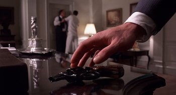 Movie still from “No Way Out” (1987), directed by Roger Donaldson – A hand is reaching for something on a table; Extreme Close Up shot, Low angle