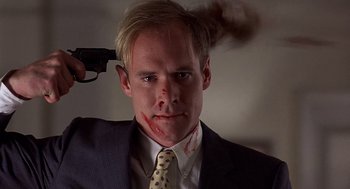 Movie still from “No Way Out” (1987), directed by Roger Donaldson – A man in a suit with a gun in his hand; Close Up shot, High angle
