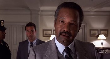 Movie still from “No Way Out” (1987), directed by Roger Donaldson – A man in a suit and tie standing next to another man in a suit and tie; Close Up shot, Low angle