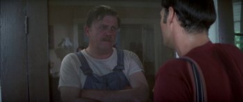 Movie still from “Norma Rae” (1979), directed by Martin Ritt – A man in a white t - shirt is talking to another man in a red shirt; Close Up shot, Over the shoulder angle