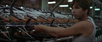 Movie still from “Norma Rae” (1979), directed by Martin Ritt – A person working in a factory with many machines; Medium shot, Low angle