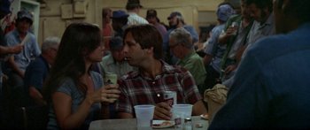 Movie still from “Norma Rae” (1979), directed by Martin Ritt – A group of people sitting at a table with drinks; Medium shot, Over the shoulder angle