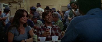 Movie still from “Norma Rae” (1979), directed by Martin Ritt – A man sitting at a table holding a cell phone; Medium shot, Over the shoulder angle