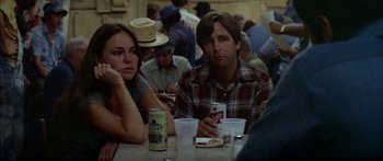 Movie still from “Norma Rae” (1979), directed by Martin Ritt – A group of people sitting at a table with drinks; Medium shot, Over the shoulder angle