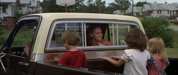Movie still from “Norma Rae” (1979), directed by Martin Ritt – A woman sitting in the back of a car with two children; Medium shot, Over the shoulder angle