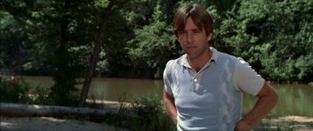 Movie still from “Norma Rae” (1979), directed by Martin Ritt – A man standing next to a body of water near trees; Medium shot, Low angle