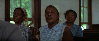 Movie still from “Norma Rae” (1979), directed by Martin Ritt – An older woman holding a picture of jesus; Close Up shot, Low angle