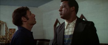 Movie still from “Norma Rae” (1979), directed by Martin Ritt – Two men are standing next to each other in a room; Medium shot, Low angle