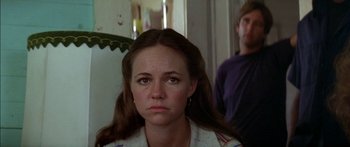 Movie still from “Norma Rae” (1979), directed by Martin Ritt – A young woman with long brown hair looking sad while a man stands in the background; Close Up shot, Over the shoulder angle