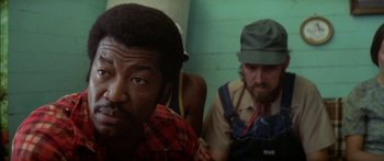 Movie still from “Norma Rae” (1979), directed by Martin Ritt – A man with a beard and a man with a green hat; Close Up shot, Over the shoulder angle