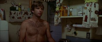 Movie still from “Norma Rae” (1979), directed by Martin Ritt – A shirtless man in a kitchen next to a sink; Medium shot, Low angle