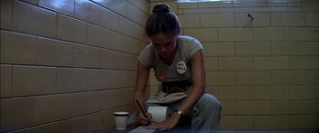 Movie still from “Norma Rae” (1979), directed by Martin Ritt – A woman writing on a piece of paper in front of a cup; Medium shot, High angle