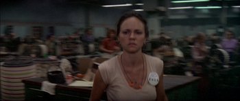 Movie still from “Norma Rae” (1979), directed by Martin Ritt – A woman in a tan shirt is standing in front of a group of people; Close Up shot, Low angle
