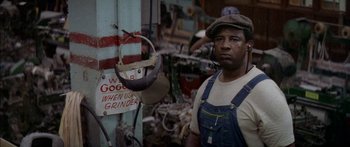 Movie still from “Norma Rae” (1979), directed by Martin Ritt – A man standing next to an industrial machine in a shop; Close Up shot, Low angle