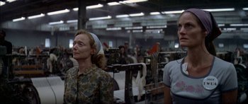 Movie still from “Norma Rae” (1979), directed by Martin Ritt – An older woman wearing a headscarf in a factory; Medium shot, Low angle