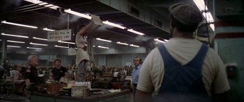 Movie still from “Norma Rae” (1979), directed by Martin Ritt – A woman standing on a table in a room; Wide shot, High angle
