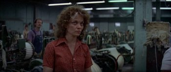 Movie still from “Norma Rae” (1979), directed by Martin Ritt – A woman standing in a room filled with machines; Close Up shot, Low angle