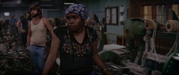 Movie still from “Norma Rae” (1979), directed by Martin Ritt – A woman wearing a head scarf standing in a room; Close Up shot, High angle