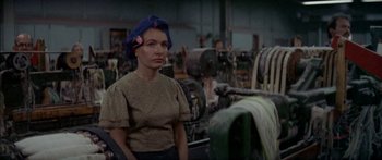 Movie still from “Norma Rae” (1979), directed by Martin Ritt – A woman wearing a hat standing next to a machine; Close Up shot, High angle