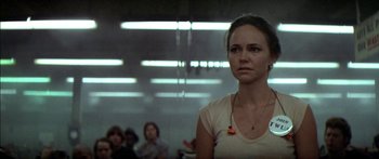 Movie still from “Norma Rae” (1979), directed by Martin Ritt – A woman standing in front of a group of people in a room; Close Up shot, Low angle
