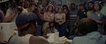 Movie still from “Norma Rae” (1979), directed by Martin Ritt – A group of people standing around a table with papers on top of it; Medium shot, High angle