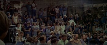 Movie still from “Norma Rae” (1979), directed by Martin Ritt – A large group of people sitting in front of a brick wall; Extreme Wide shot, High angle