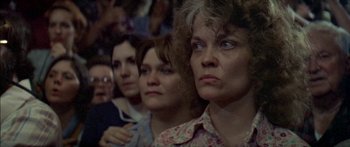 Movie still from “Norma Rae” (1979), directed by Martin Ritt – A group of people sitting in a row watching something; Close Up shot, High angle
