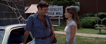 Movie still from “Norma Rae” (1979), directed by Martin Ritt – A man and a woman standing next to each other; Medium shot, Over the shoulder angle