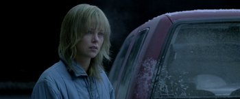 Movie still from “North Country” (2005), directed by Niki Caro – A woman standing in front of a red car; Close Up shot, Over the shoulder angle