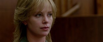 Movie still from “North Country” (2005), directed by Niki Caro – Charlize theron looking to her left while sitting in a chair; Close Up shot, Over the shoulder angle