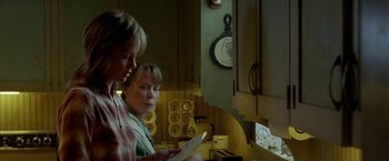 Movie still from “North Country” (2005), directed by Niki Caro – Two women in a kitchen looking at something on a tablet; Medium shot, Low angle