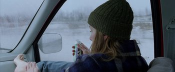 Movie still from “North Country” (2005), directed by Niki Caro – A woman sitting in a car holding a can of soda; Medium shot, Over the shoulder angle