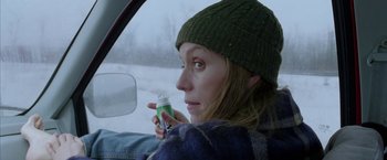 Movie still from “North Country” (2005), directed by Niki Caro – A woman sitting in the drivers seat of a car holding a bottle; Close Up shot, Over the shoulder angle