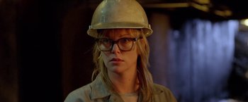 Movie still from “North Country” (2005), directed by Niki Caro – A woman wearing glasses and a hard hat; Close Up shot, Over the shoulder angle